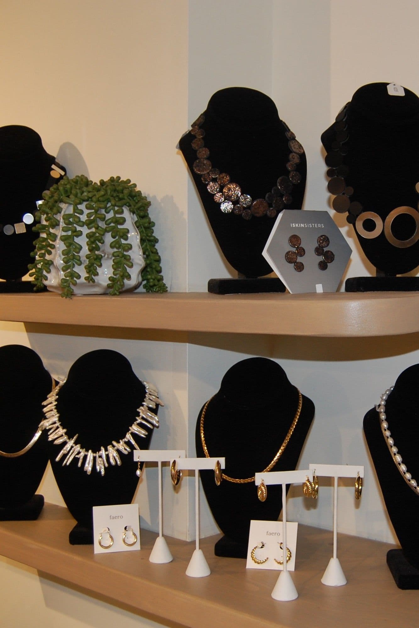 Jewellery display with hammered-bronze necklaces and Iskinsisters earrings