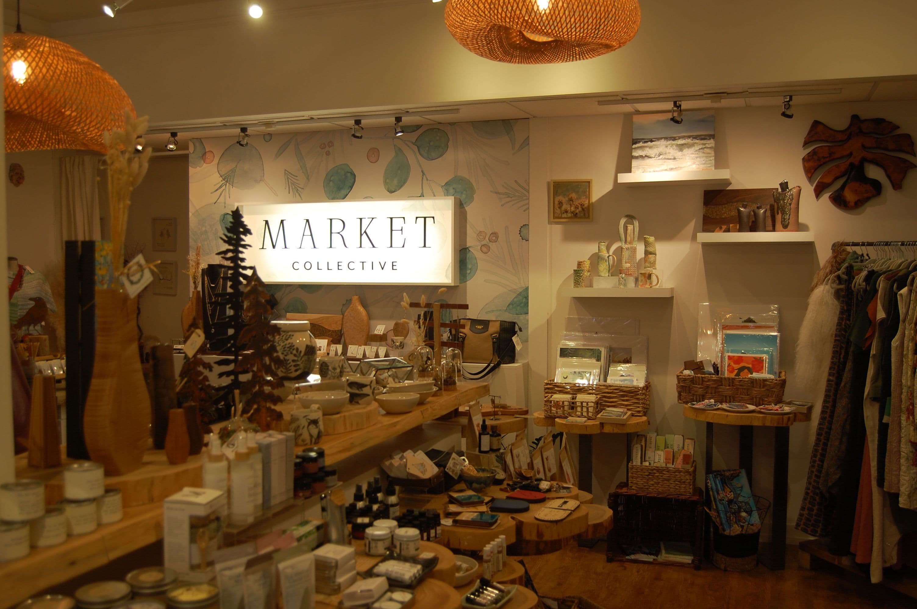 Market Collective interior with branded wordmark on the wall and woven pendant lights