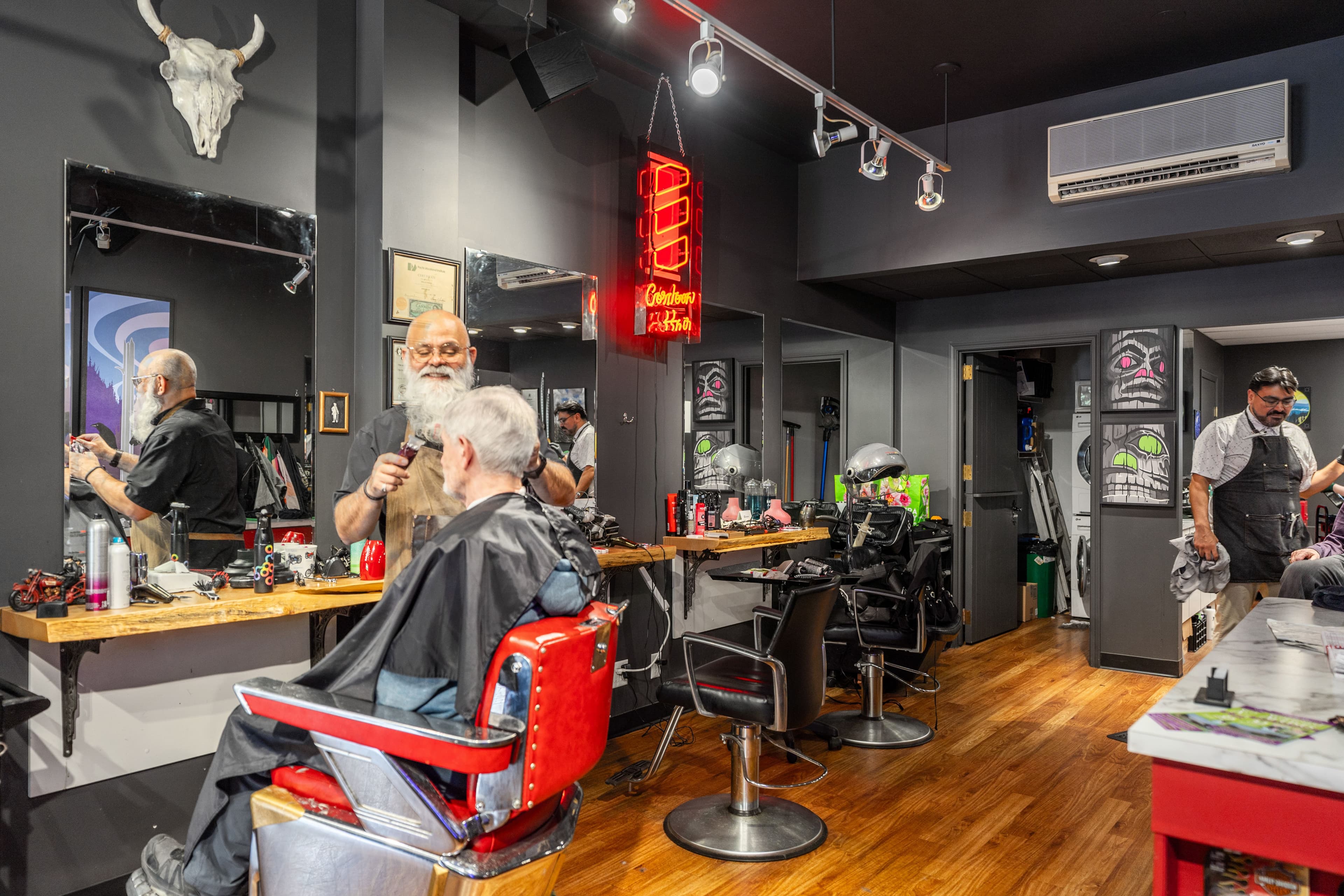 Cordova Hair neon sign glowing red beside the barber chairs and station mirror