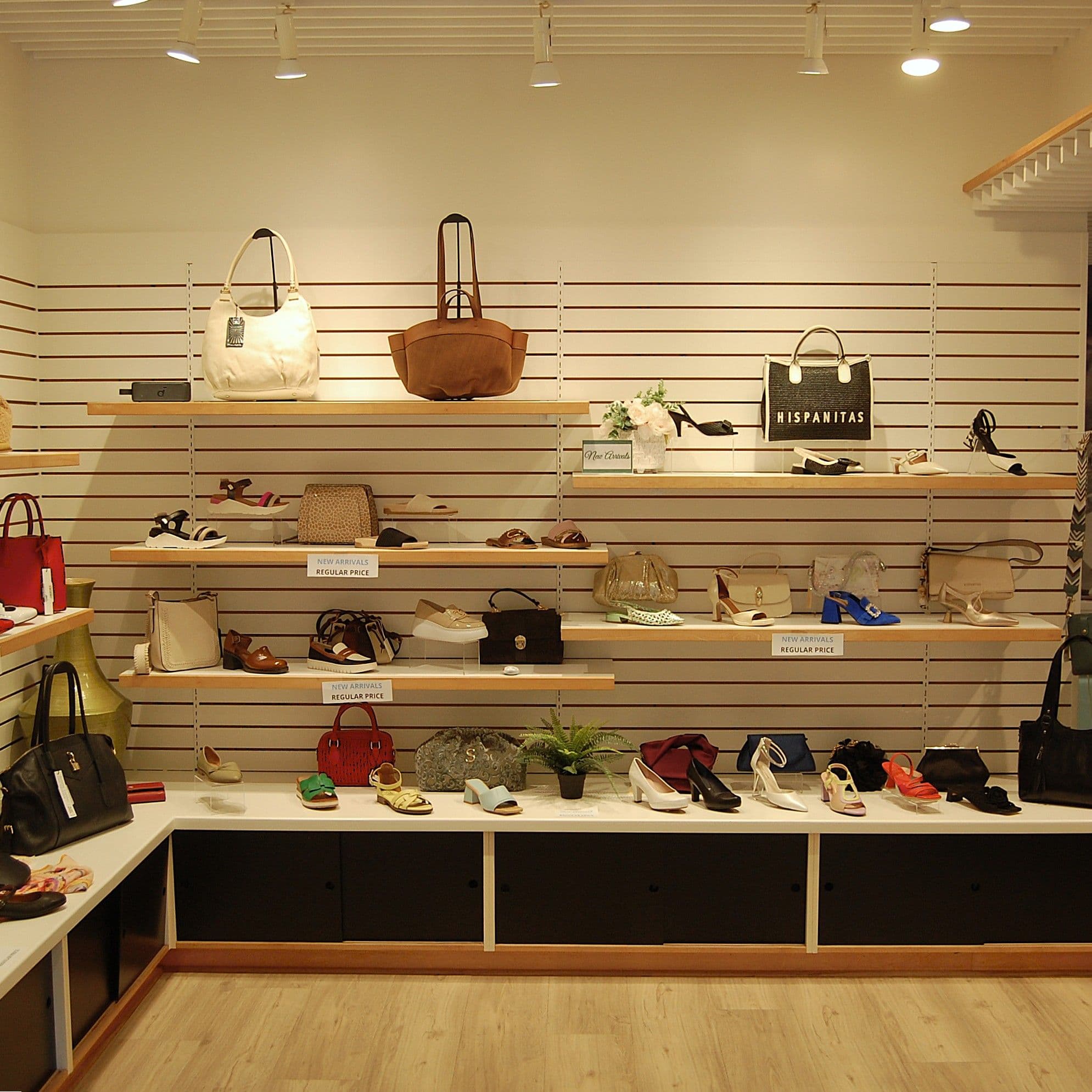 Retail wall with handbags, shoes and a row of green succulents