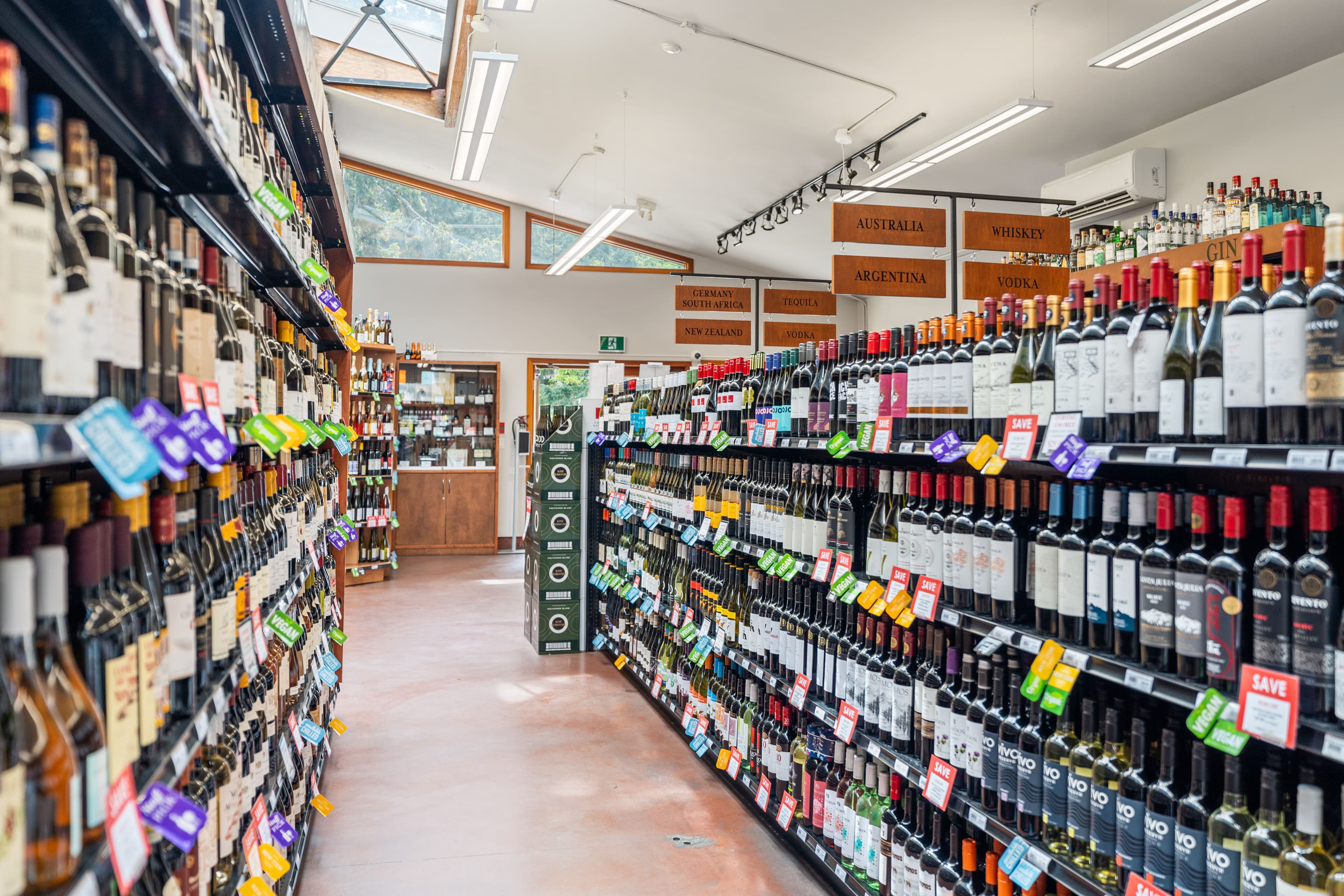International wine aisle under a skylight with country signs