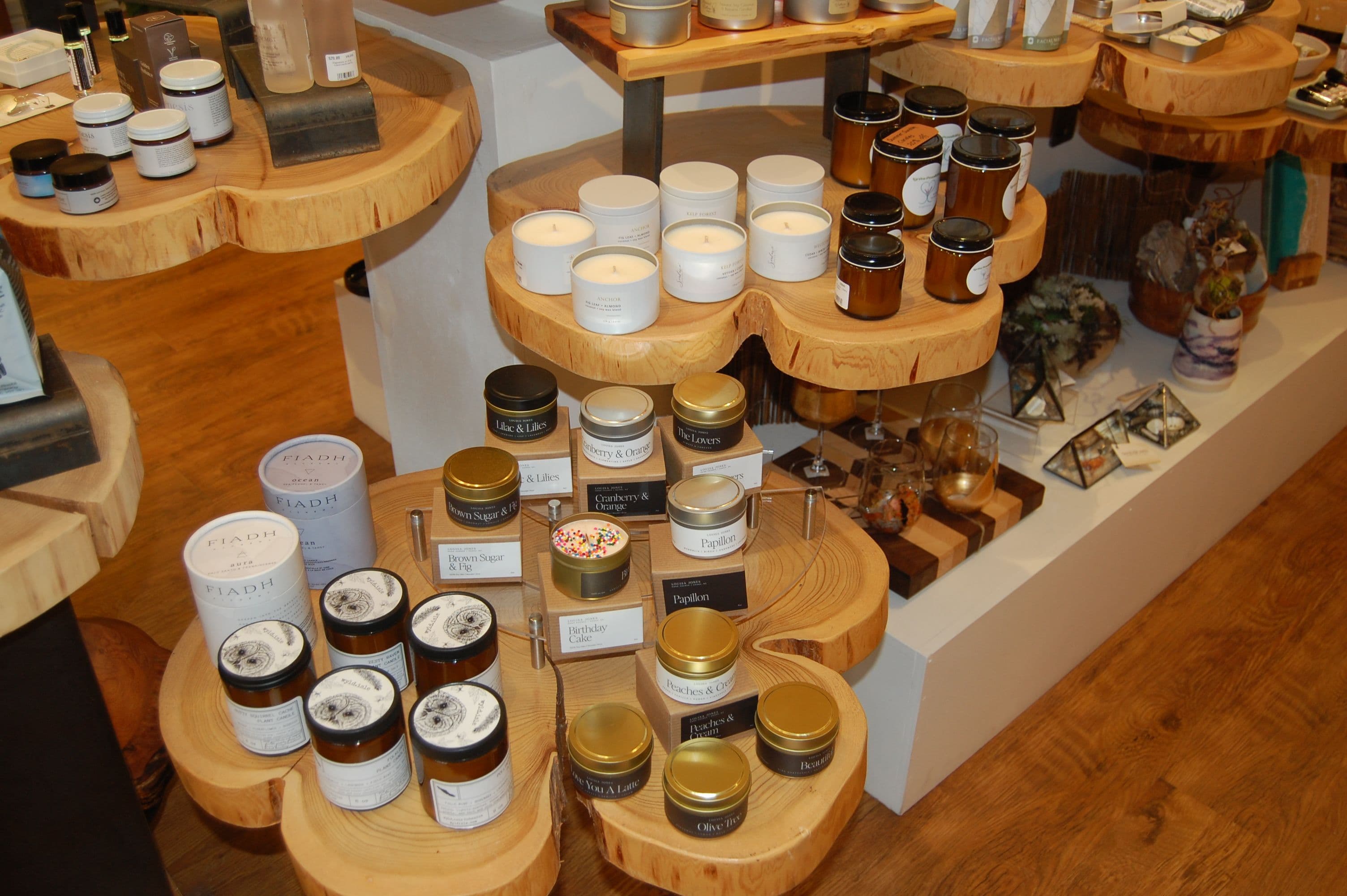 Top-down view of candle jars on rounded wood-slab display tables