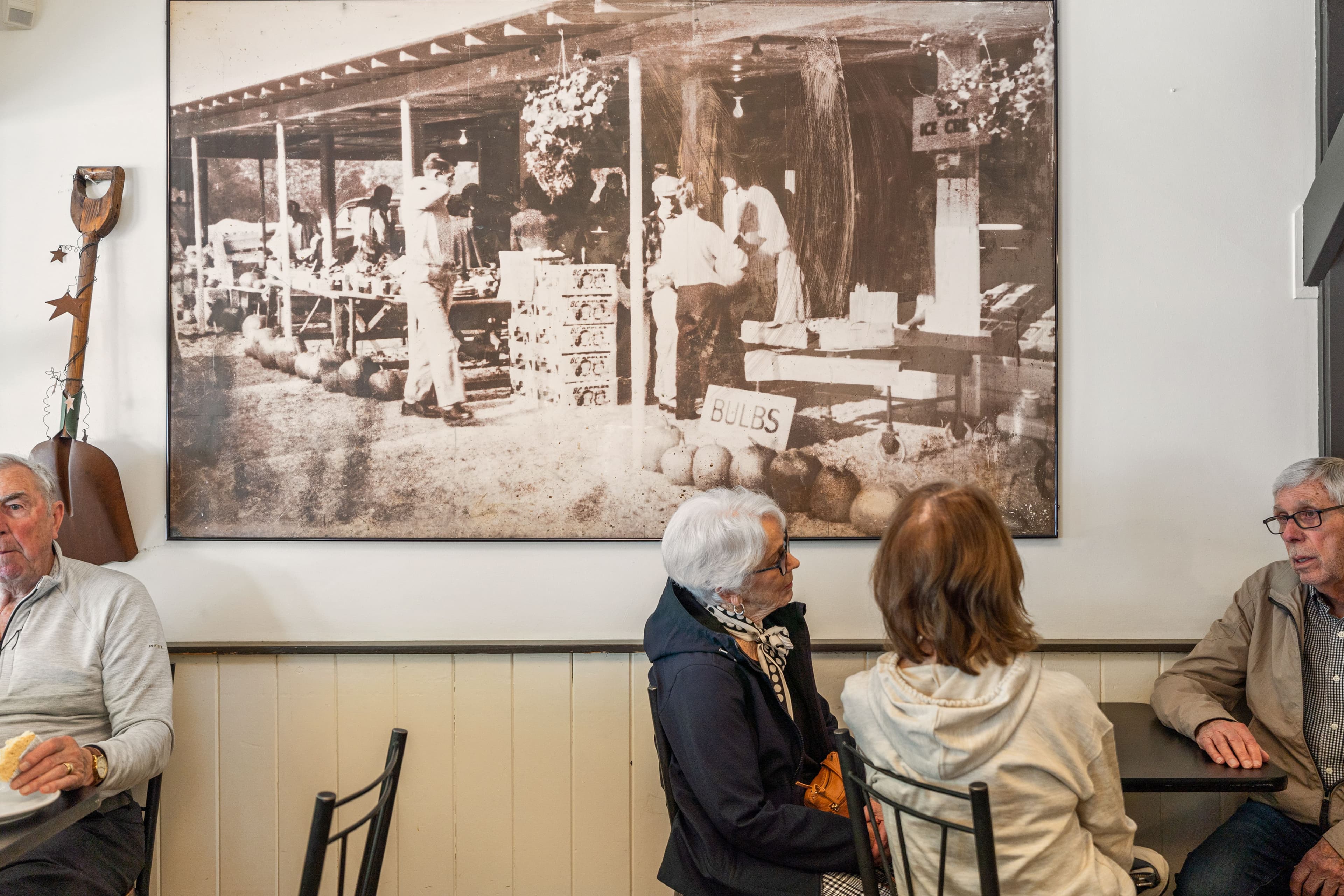 Customers seated below a large historic photograph of Mattick's Farm