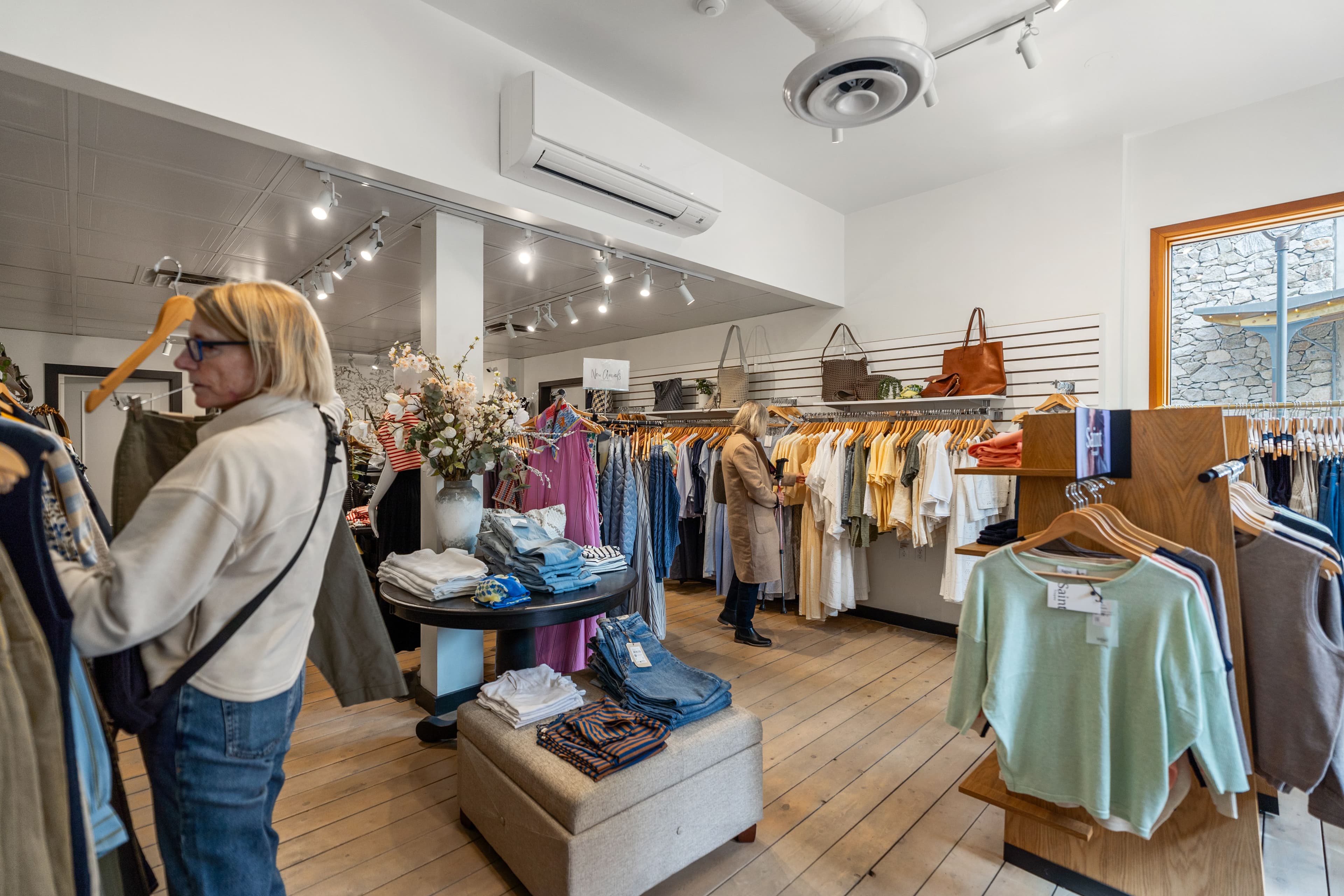 Customer browsing the rack with a vase of dried florals on the centre table