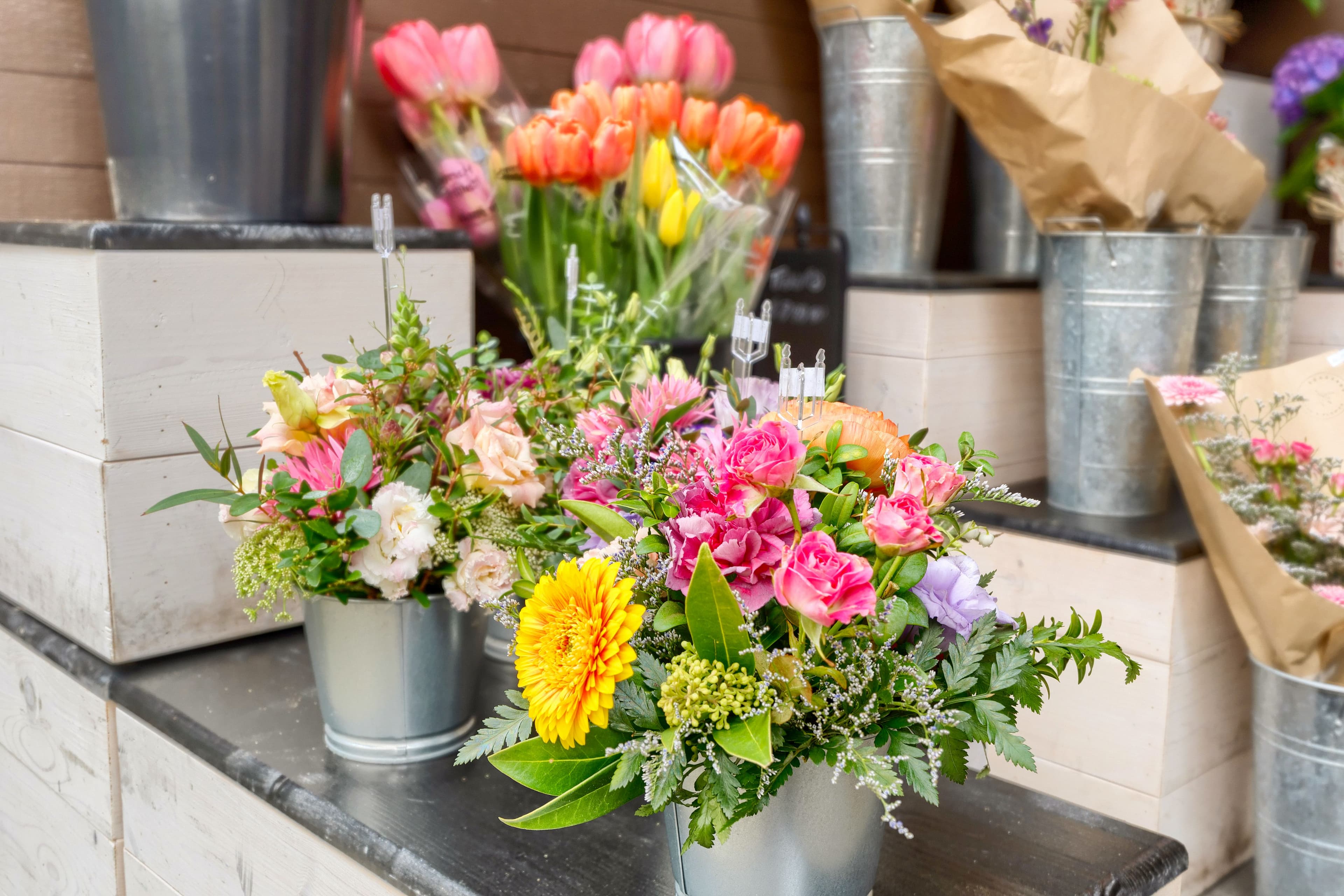 Fresh tulips and a floral arrangement in a galvanised pail