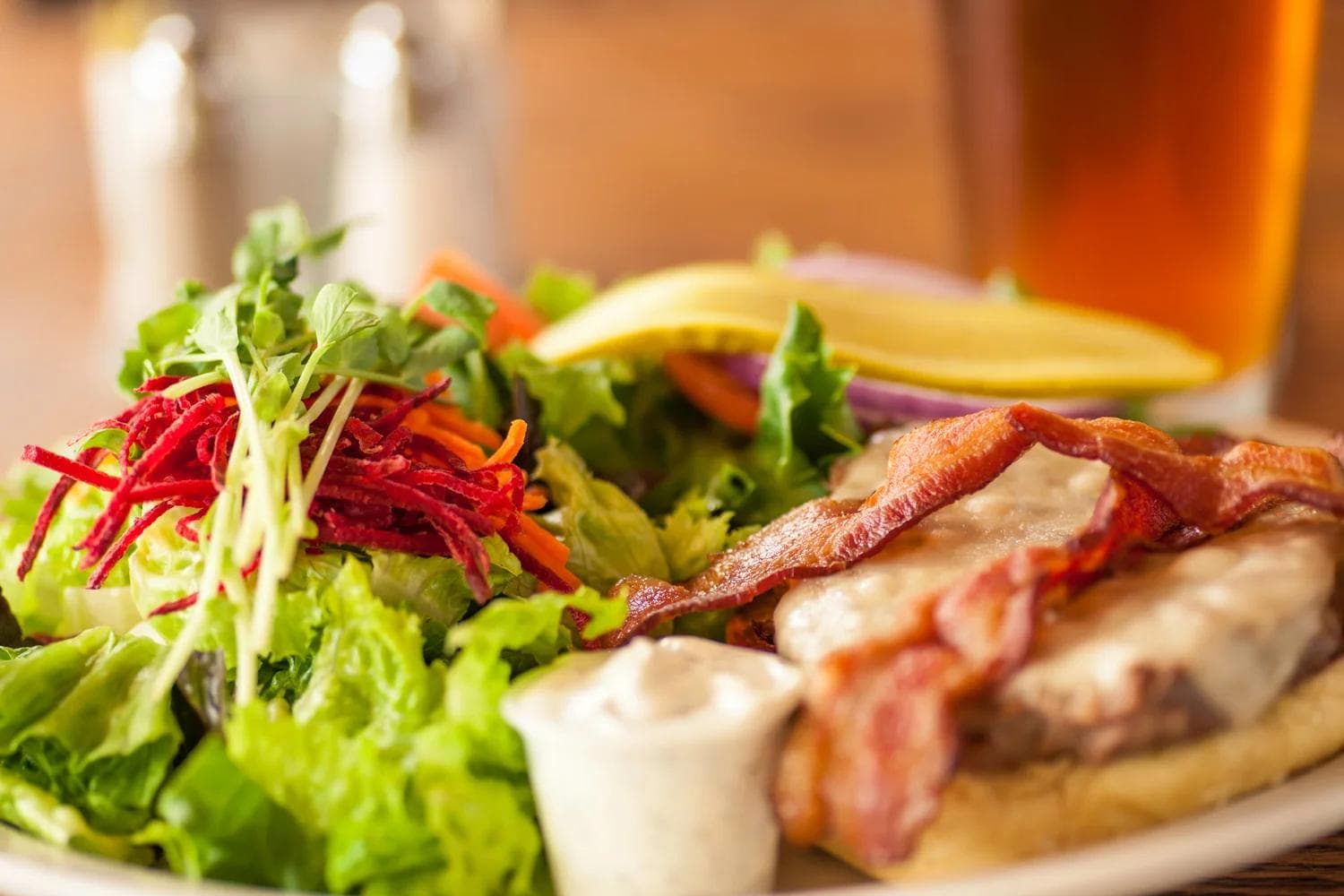 Bacon sandwich with side salad and a beer