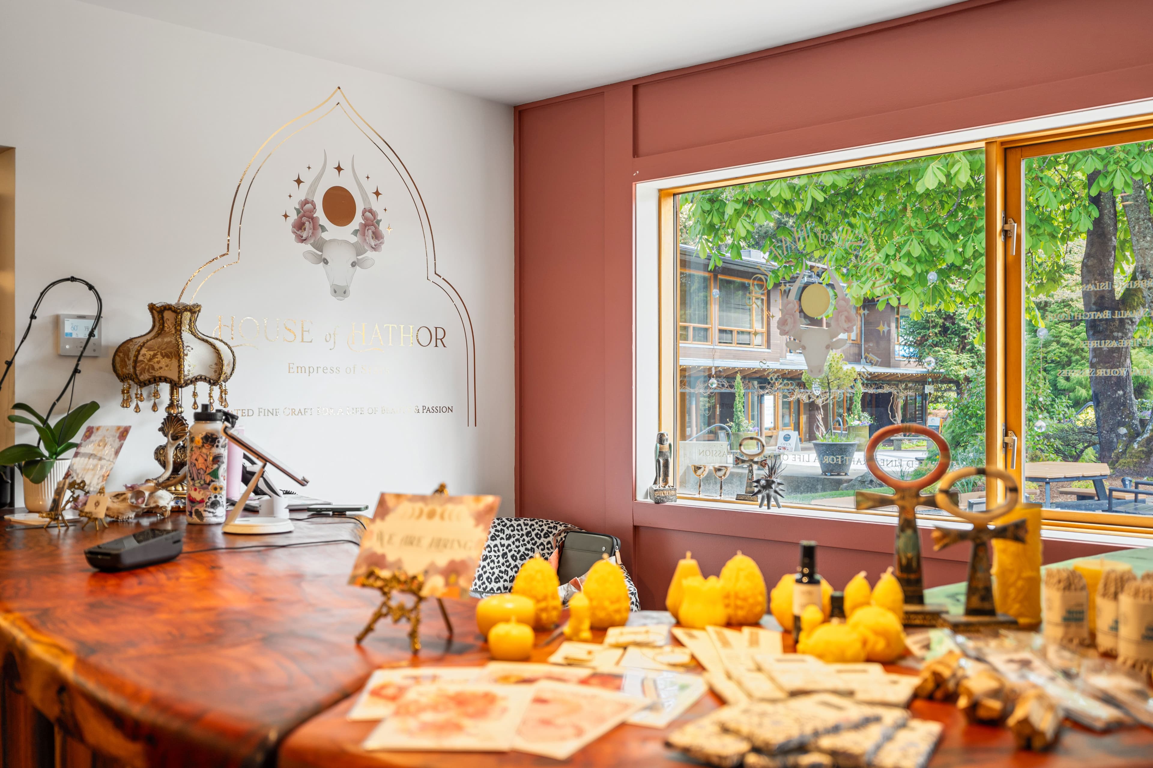 House of Hathor branded wall behind a wooden counter with candles and decor