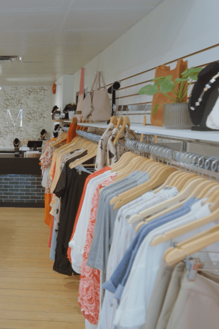 View along the garment racks with the M wordmark on the back wall