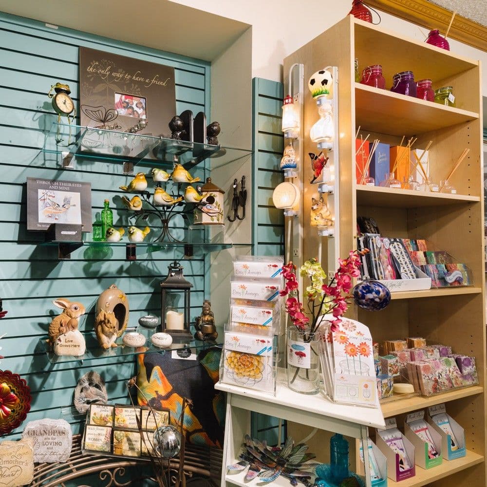Gift display with ceramic birds and 'the only way to have a friend' artwork