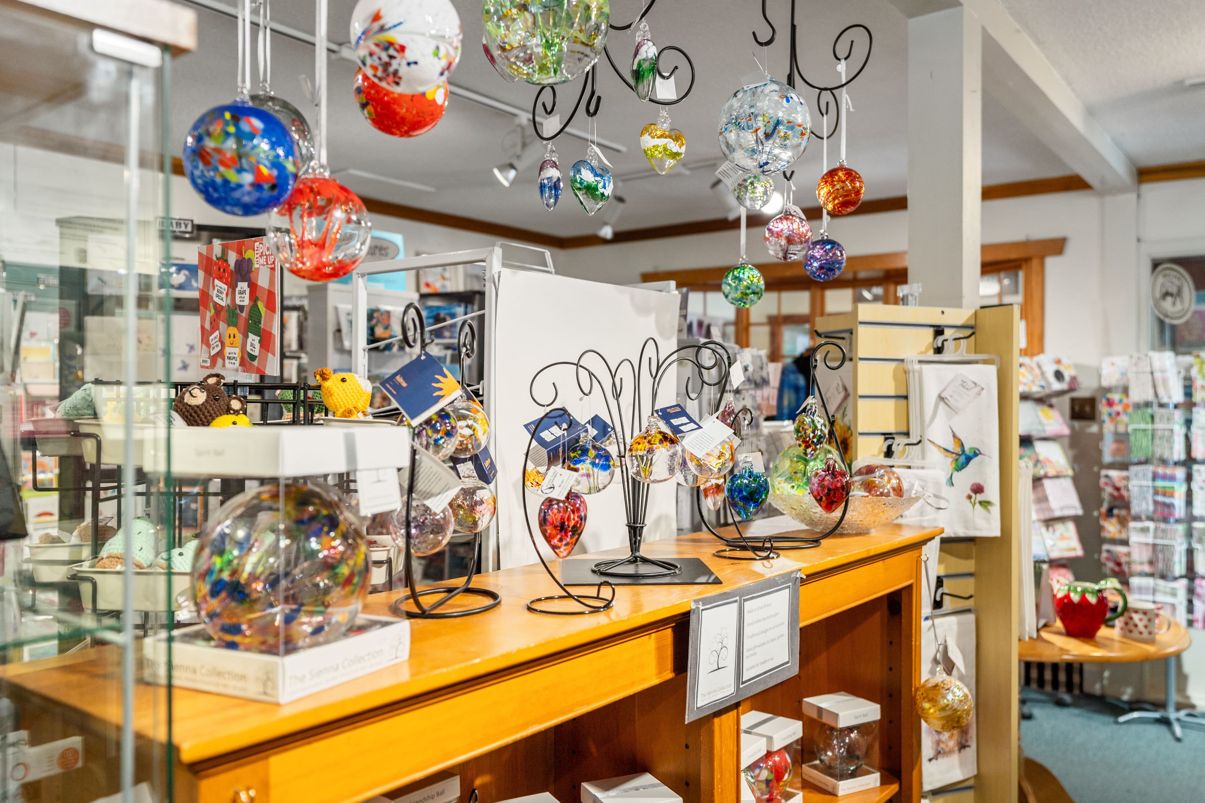 Hand-blown glass ornaments hanging above the gift display cases