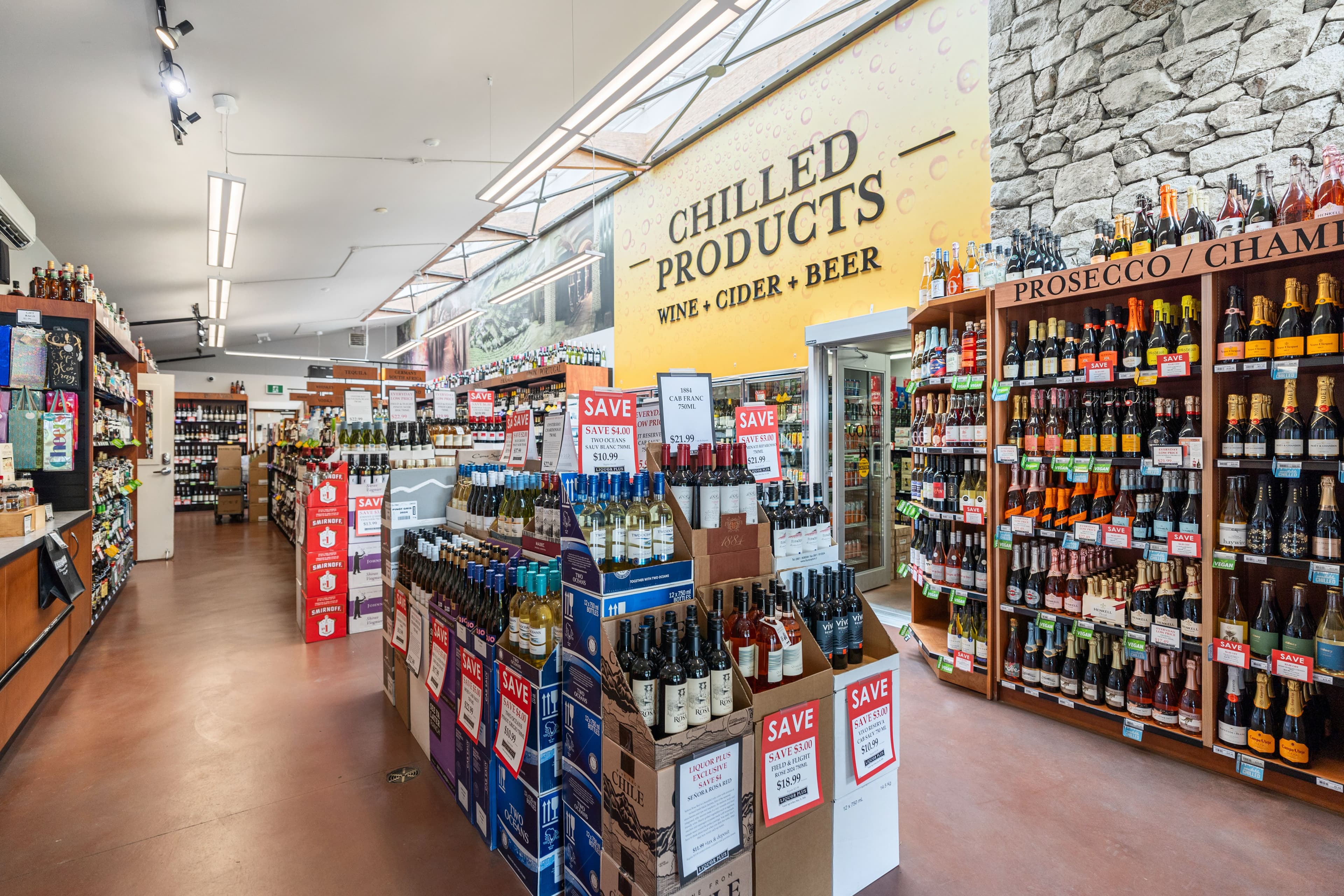 Liquor Plus interior with Chilled Products signage and prosecco/champagne wall