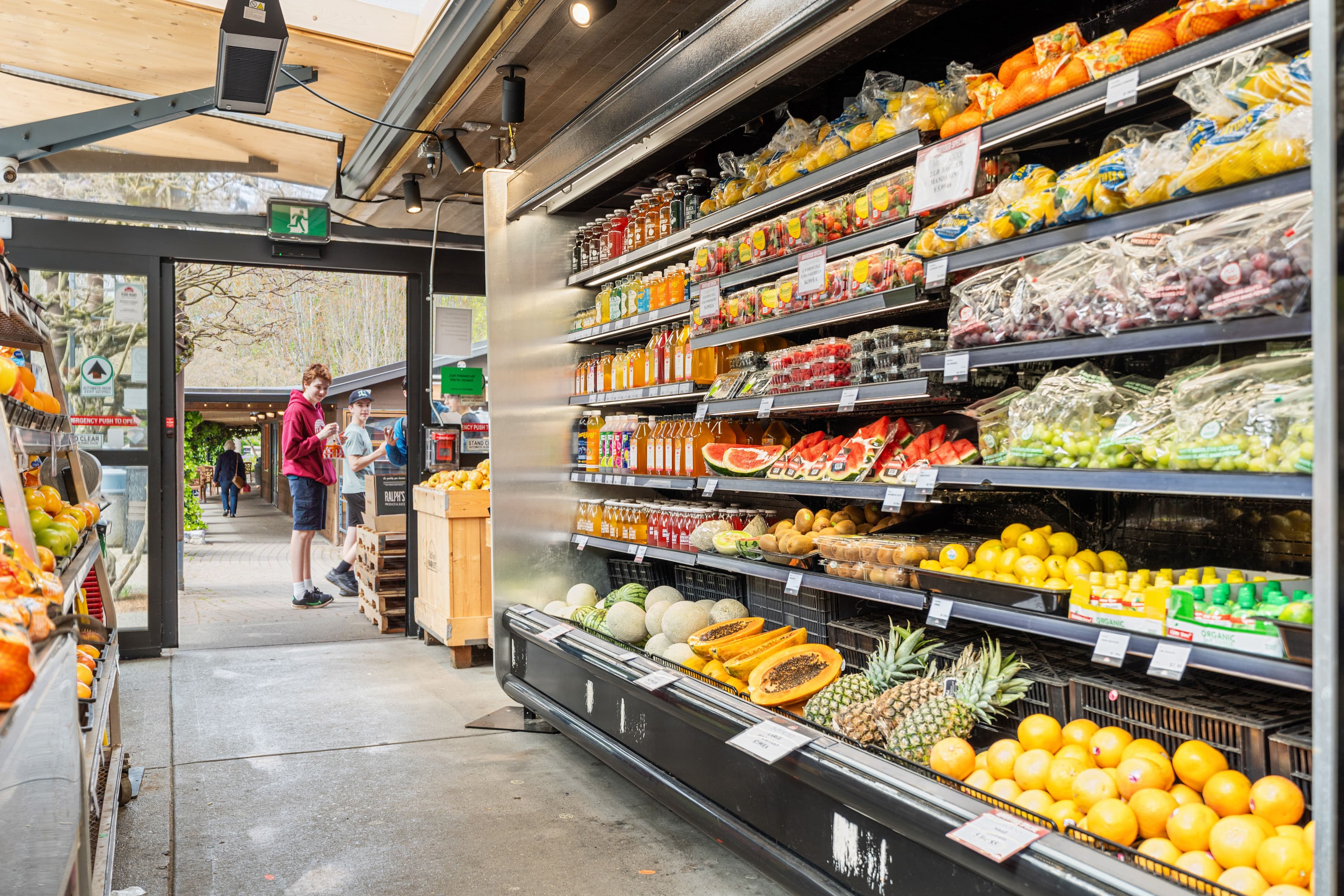 Wide produce section with melons, citrus and the open doorway beyond